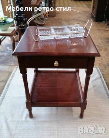 Стилна помощна масичка от масивно дърво в класически тъмен цвят. Разполага с удобно чекмедже.