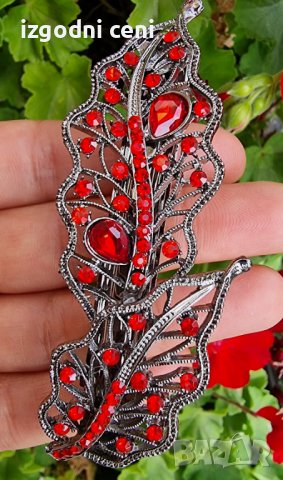 Луксозна шнола с метален механизъм с форма на листо, обкичена с червени кристали 