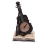 Часовник във формата на цигулка върху книга.