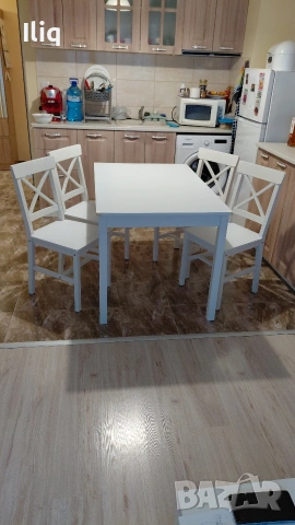 бяла дървена маса с четери стола. 