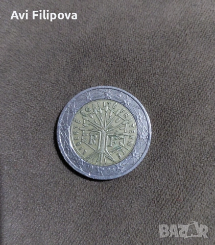 Монетата от 2 евро на снимката е френска емисия, известна като „Дървото на живота“ (Arbre de la Vie)