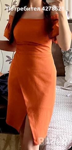 Стилна оранжева рокля с открити рамене, която подчертава фигурата и придава модерна, женствена визия