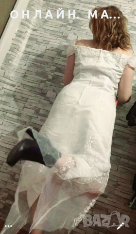 Елегантна къса  рокля с падащ ръкав, изработена от висококачествена дантела в бял цвят.